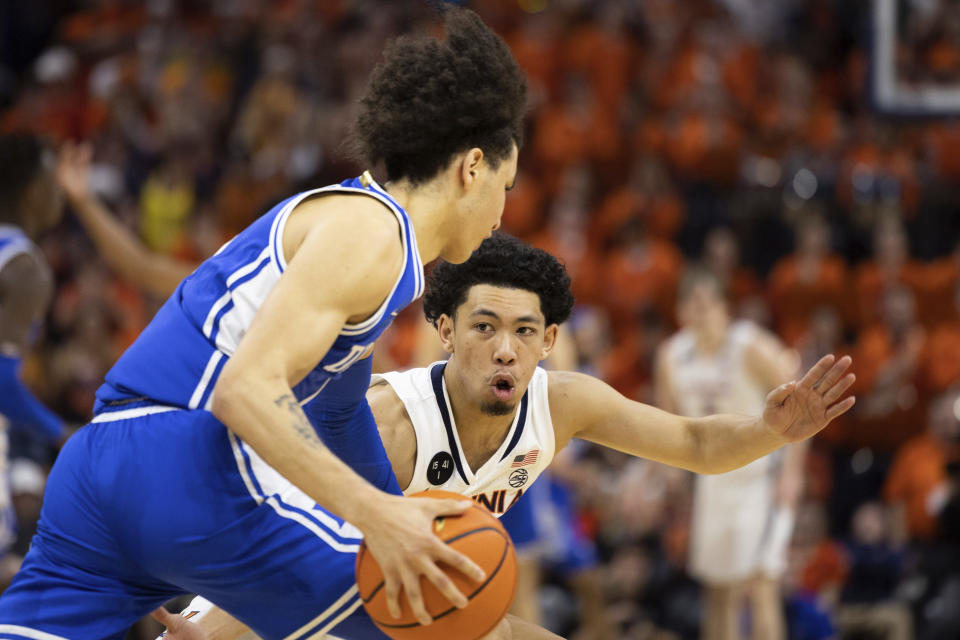 Duke's Tyrese Proctor (5) is defended by Virginia's Kihei Clark (0) during the second half of an NCAA college basketball game in Charlottesville, Va., Saturday, Feb. 11, 2023. (AP Photo/Mike Kropf)