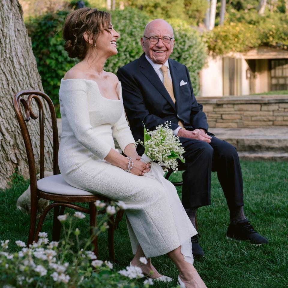 Mr Murdoch and his wife sat on chairs and smiling broadly