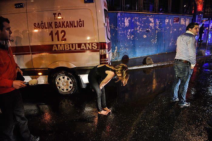 A woman reacts next to an ambulance near the scene of the attack. Image: AAP