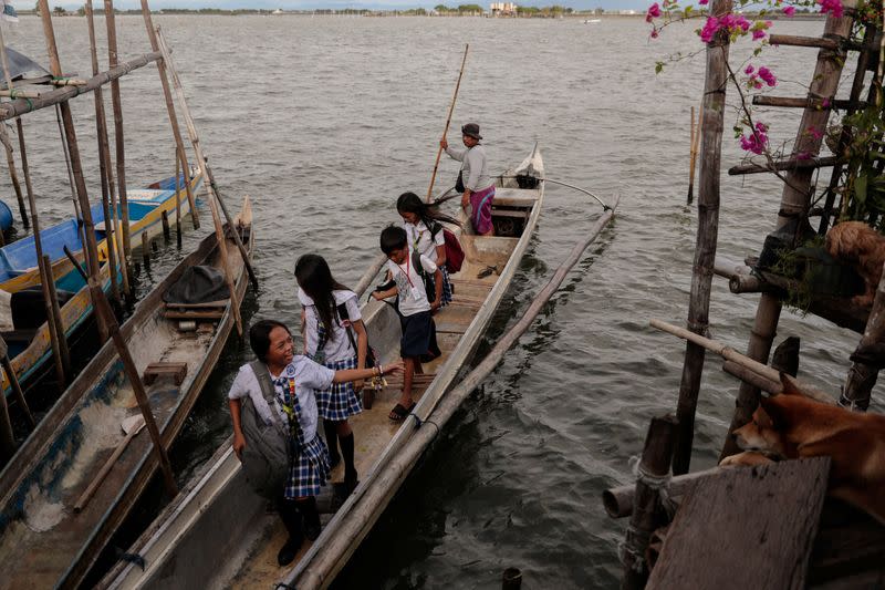 The Wider Image: Rising seas threaten early end for sinking village in Philippines