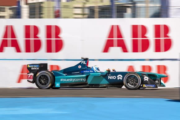 A NIO Formula E single-seat electric race car, shown at speed on a track.