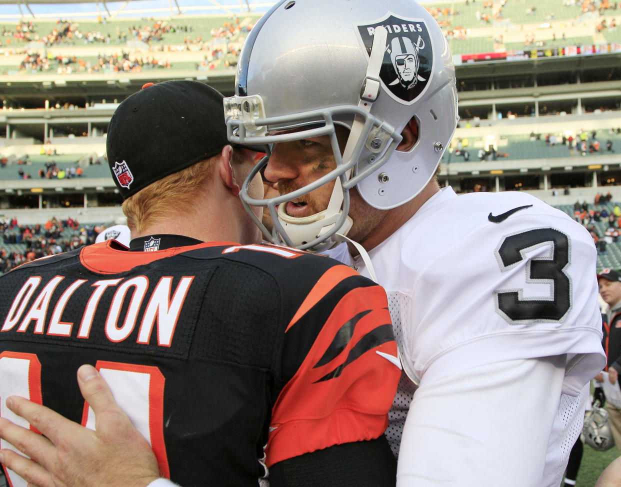 Oakland Raiders quarterback Carson Palmer (3) hugs Cincinnati Bengals quarterback Andy Dalton (14) after the Bengals defeated the Raiders 34-10 in an NFL football game, Sunday, Nov. 25, 2012, in Cincinnati. (AP Photo/David Kohl)