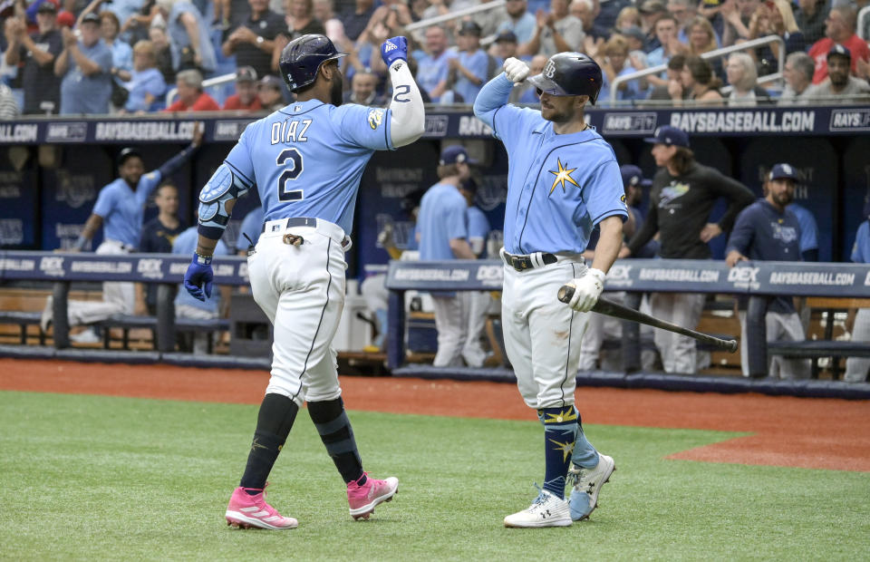 Tampa Bay Rays' Yandy Diaz (2) celebrates after his solo home off Boston Red Sox starter Corey Kluber with Brandon Lowe, right, during the first inning of a baseball game Thursday, April 13, 2023, in St. Petersburg, Fla. (AP Photo/Steve Nesius)