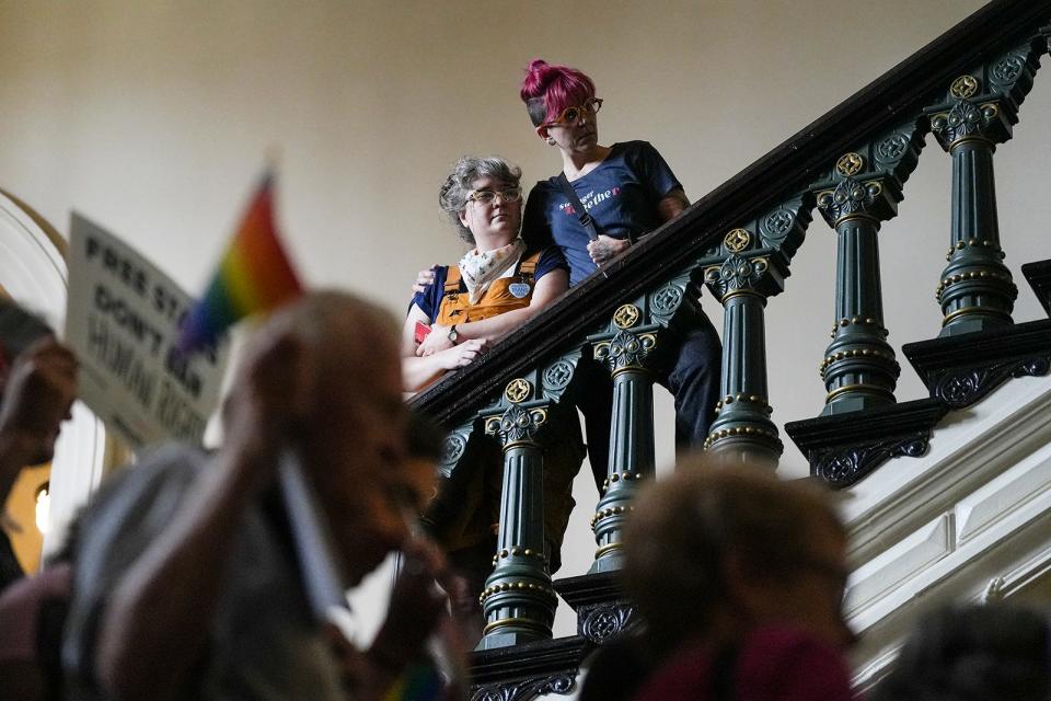 LGBTQ+ activists Kristi and Nick Winges-Yanez embrace as they protest SB 14 at the Capitol on Friday.