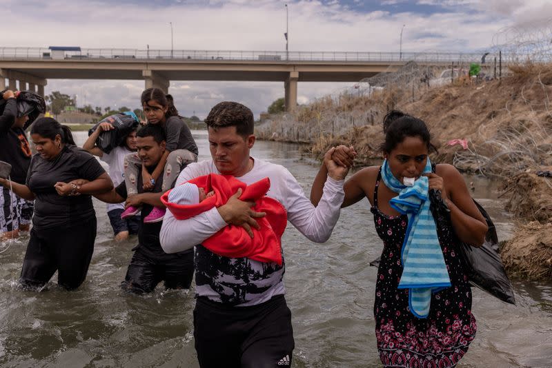 Cuban migrants wade along bank of Rio Grande river in Eagle Pass