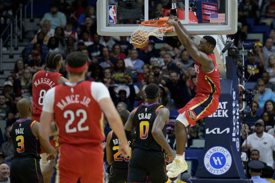 New Orleans Pelicans forward Zion Williamson, right, dunks against Phoenix Suns forward Torrey Craig (0) in the first half of an NBA basketball game in New Orleans, Friday, Dec. 9, 2022. (AP Photo/Matthew Hinton)