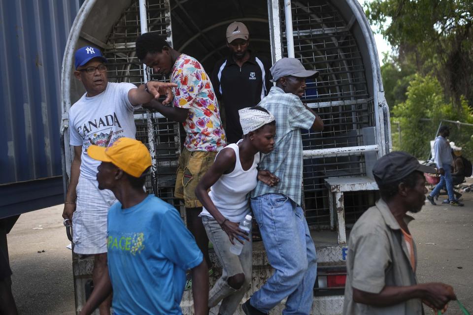Undocumented Haitians, detained by immigration officials, step out of a bus to be deported to Haiti, in Dajabon, Dominican Republic, Friday, Nov. 19, 2021. More than 31,000 people have been deported by the Dominican Republic to Haiti this year, more than 12,000 of them in just the past three months -- a huge spike, observers say. (AP Photo/Matias Delacroix)