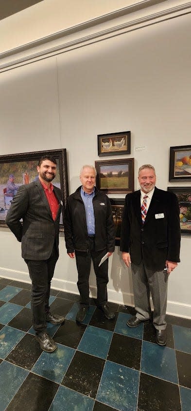 Allen Hutton (center) stands with Richmond Art Museum Education Director Lance Crow (left) and Executive Director Shaun Dingwerth in front of his oil painting "Golden Hour" at the 125th Annual Exhibition of Indiana and Ohio Artists at the Richmond Art Museum, Thursday, Nov. 9, 2023.