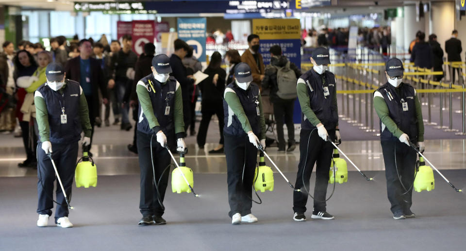 Workers spray antiseptic solution on the arrival lobby amid rising public concerns over the possible spread of a new coronavirus at Incheon International Airport in Incheon, South Korea, Tuesday, Jan. 21, 2020. Heightened precautions were being taken in China and elsewhere Tuesday as governments strove to control the outbreak of a novel coronavirus that threatens to grow during the Lunar New Year travel rush. (Suh Myung-geon/Yonhap via AP)