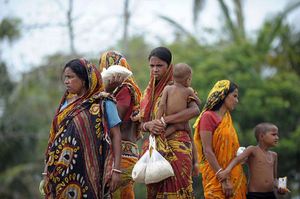 Indian villagers collect donated food from a social work organisation in the cyclone-hit village of Kumirmari in the Sundarbans in 2009 (AFP via Getty)