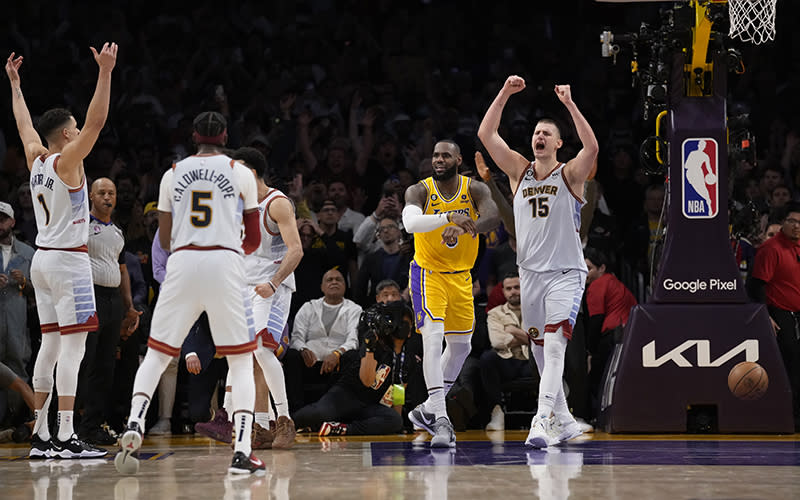 Denver Nuggets center Nikola Jokic, right, celebrates after Los Angeles Lakers forward LeBron James, second from right, missed a shot attempt