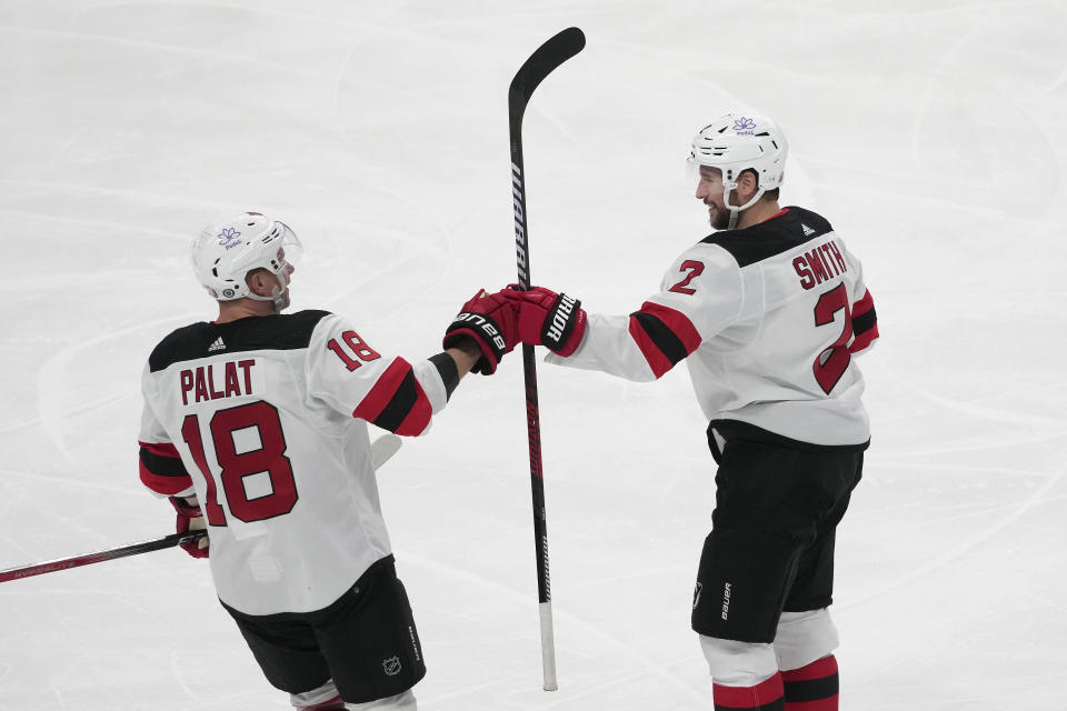 New Jersey Devils defenseman Brendan Smith, right, is congratulated by left wing Ondrej Palat (18) after scoring against the San Jose Sharks during the third period of an NHL hockey game in San Jose, Calif., Tuesday, Feb. 27, 2024. (AP Photo/Jeff Chiu)