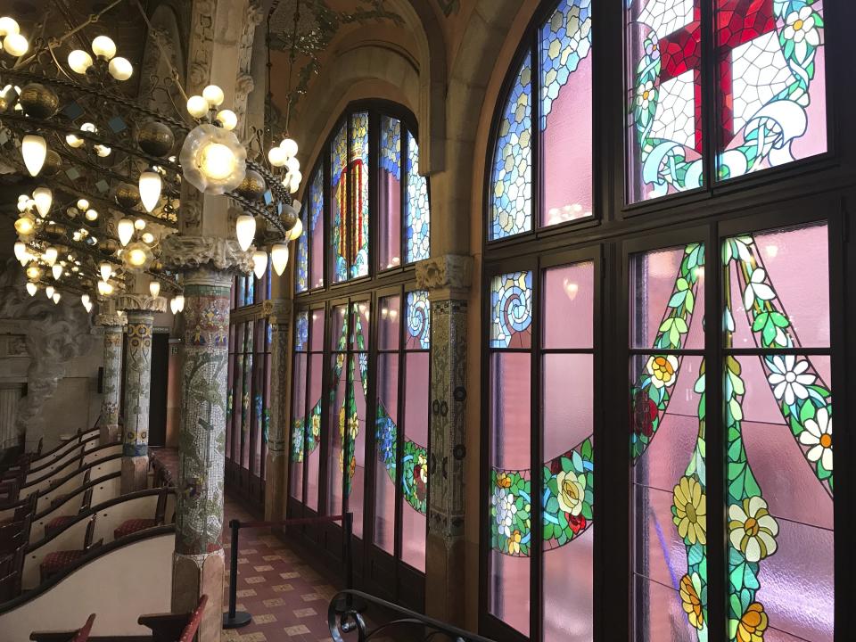 This Oct. 14, 2019 photo shows the inside of Palau de la Música Catalana, built by famed architect Lluís Domènech I Montaner, in Barcelona, Spain. A required tour of the music hall’s crescendo of colorful stained glass and mosaics is pricey but worth it, and you may even catch musicians practicing. (Courtney Bonnell via AP)