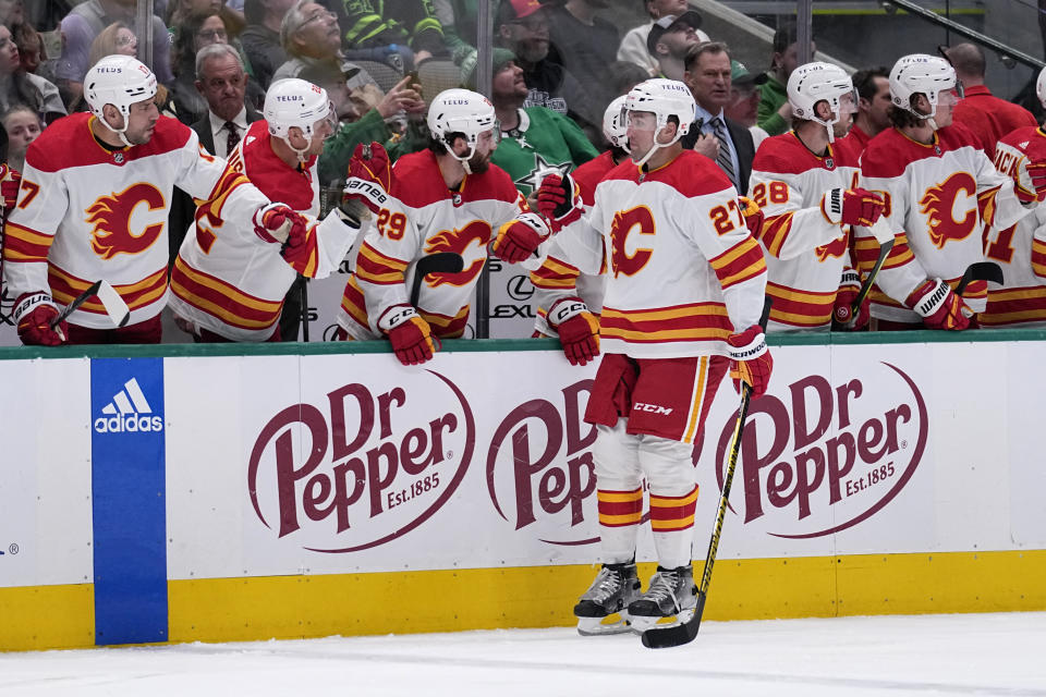 Calgary Flames left wing Nick Ritchie (27) celebrates with the bench after scoring in the second period of an NHL hockey game against the Dallas Stars, Monday, March 6, 2023, in Dallas. (AP Photo/Tony Gutierrez)