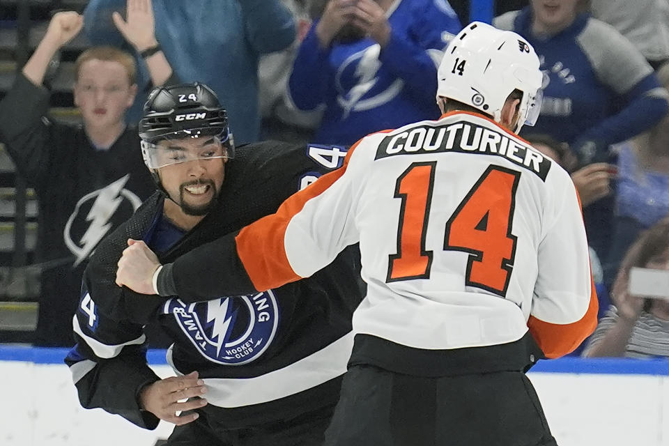Tampa Bay Lightning defenseman Matt Dumba (24) and Philadelphia Flyers center Sean Couturier (14) fight during the second period of an NHL hockey game Saturday, March 9, 2024, in Tampa, Fla. (AP Photo/Chris O'Meara)