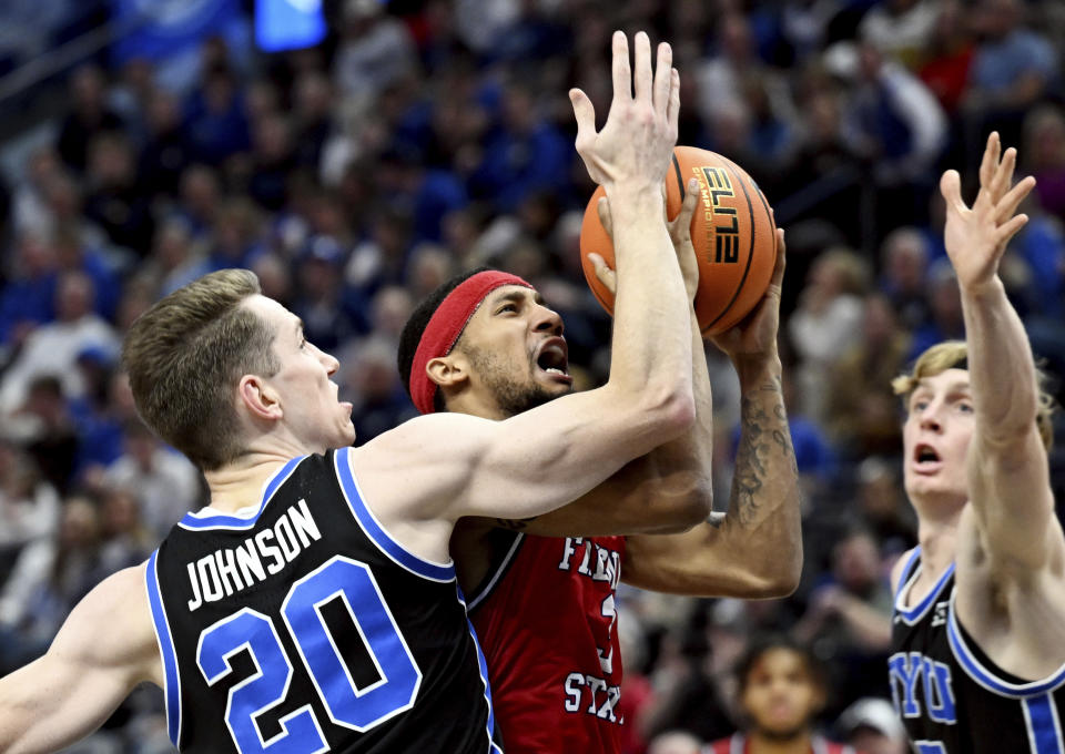 Fresno State guard Isaiah Hill (3) drives to the basket with BYU guards Spencer Johnson (20) and Richie Saunders, right, defending against him during an NCAA college basketball game in Salt Lake City, Friday, Dec. 1, 2023. (Scott G Winterton/The Deseret News via AP)