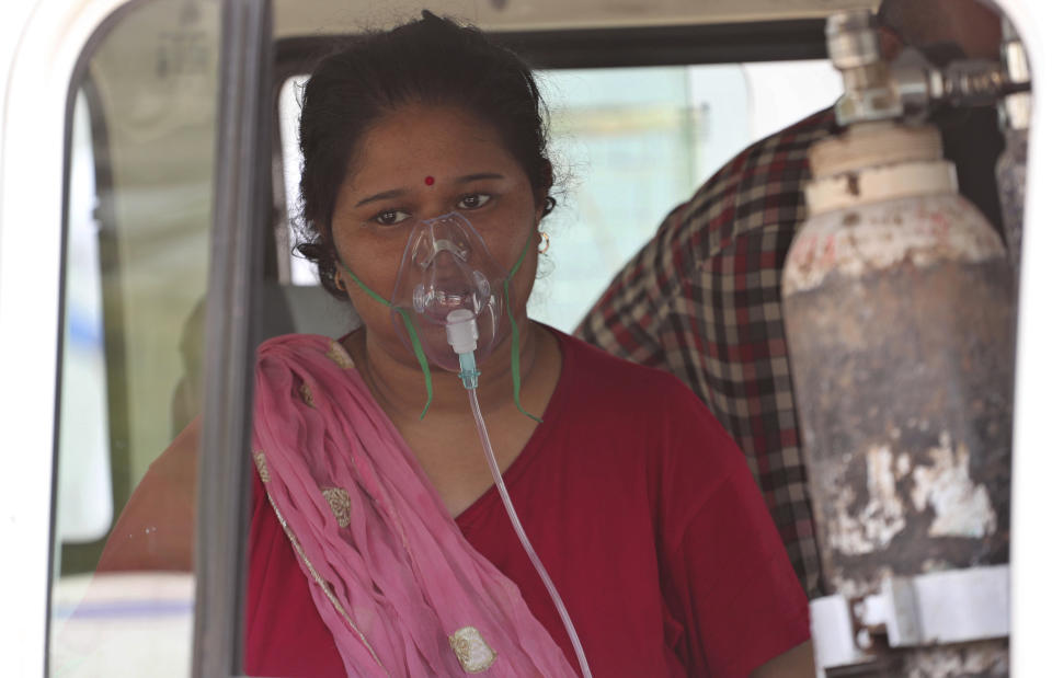 A COVID-19 patient wearing oxygen mask waits inside a vehicle to be attended and admitted in a dedicated COVID-19 government hospital in Ahmedabad, India, Thursday, April 22, 2021. India reported a global record of more than 314,000 new infections Thursday as a grim coronavirus surge in the world's second-most populous country sends more and more sick people into a fragile health care system critically short of hospital beds and oxygen. (AP Photo/Ajit Solanki)