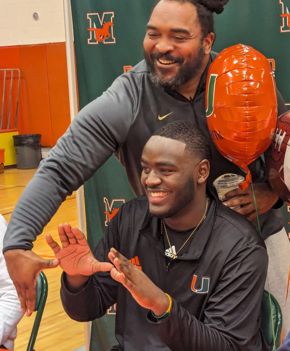 Mandarin offensive lineman Deryc Plazz makes a "U" sign after signing with Miami.