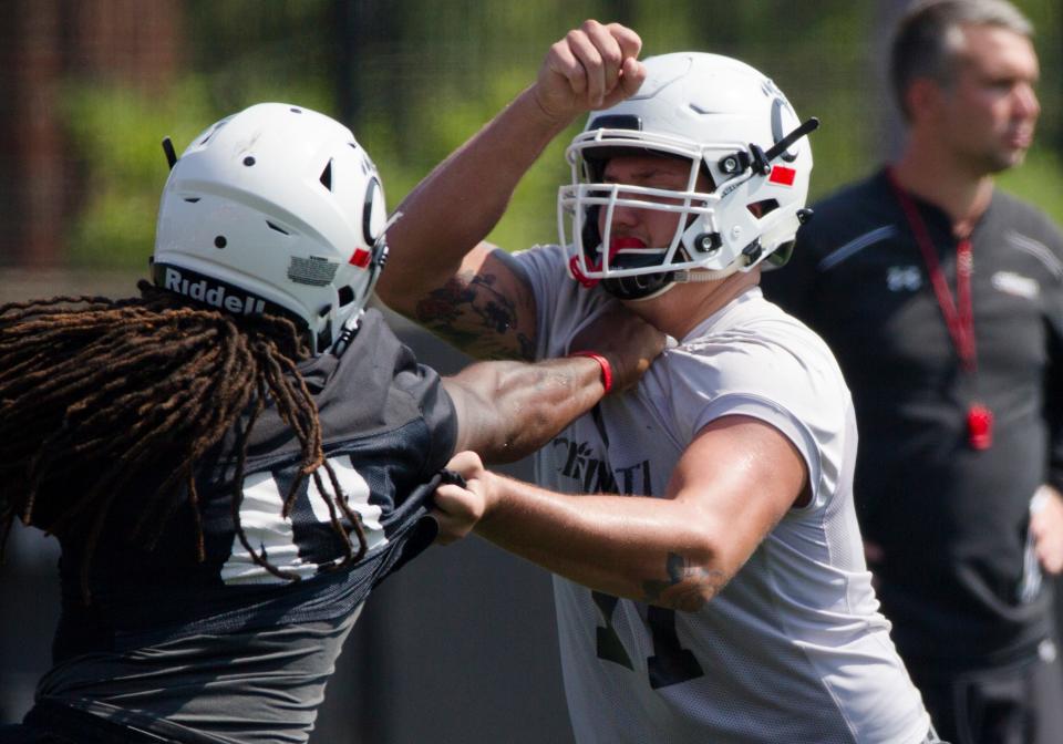 Cincinnati Bearcats offensive lineman Vincent McConnell (77) blocks Cincinnati Bearcats linebacker Michael Pitts (43) during Cincinnati Bearcats football practice Wednesday, July 31, 2019, at the University of Cincinnati. 