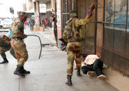 <p>Soldiers beat a supporter of the opposition Movement for Democratic Change party of Nelson Chamisa outside the party’s headquarters as they await the results of the general elections in Harare, Zimbabwe, August 1, 2018. (Photo: Mike Hutchings/Reuters) </p>