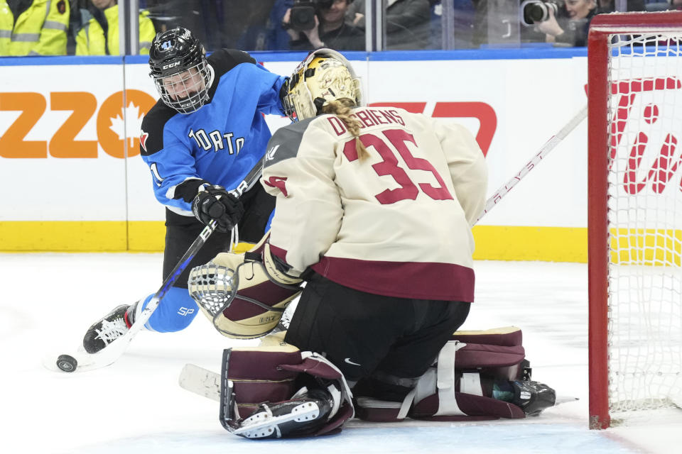 Toronto's Brittany Howard, left, shoots against Montreal goaltender Ann-Renee Desbiens, right, during third-period PWHL hockey game action in Toronto, Friday, Feb. 16, 2024. (Chris Young/The Canadian Press via AP)