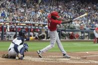 Cincinnati Reds' Aristides Aquino hits an RBI single during the 10th inning of a baseball game against the Milwaukee Brewers Sunday, Aug. 7, 2022, in Milwaukee. (AP Photo/Morry Gash)