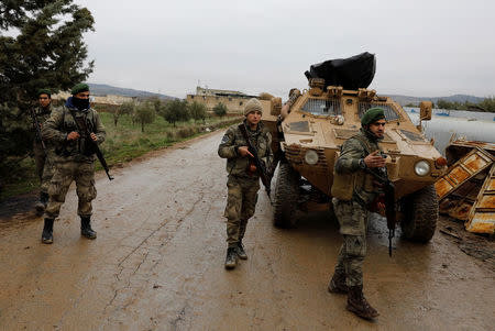 Members of Turkey-backed Free Syrian Army police forces secure the road as they escort a convoy near Azaz, Syria January 26, 2018. REUTERS/Umit Bektas