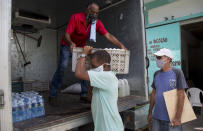 Cafeteria owner Miguel Sanchez, right, inspects his purchase as a porter loads his items into a courier service's truck, to take to his restaurant from the Mercabal wholesale market in Havana, Cuba, Friday, July 31, 2020. The government is letting private businesses buy wholesale for the first time. (AP Photo/Ismael Francisco)