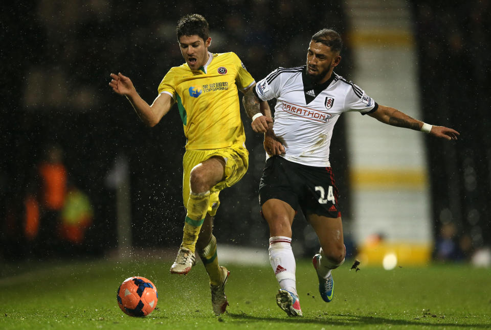 Fulham's Ashkan Dejagah, right, tackles Sheffield United's Ryan Flynn during their 4th round replay English FA Cup soccer match between Fulham and Sheffield United at Craven Cottage stadium in London, Tuesday, Feb. 4, 2014. (AP Photo/Alastair Grant)