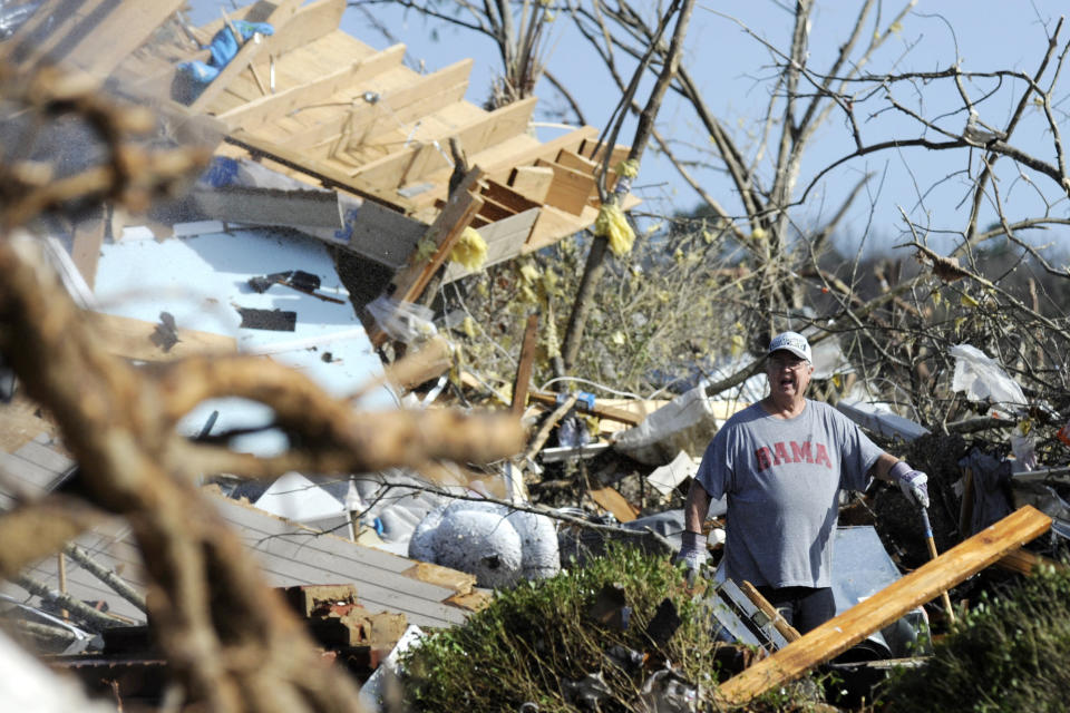 Retired firefighter Clyde Crump yells for help while working at the home of his daughter and son-in-law on Tuesday, Jan. 26, 2021, after it was destroyed by a tornado that hit Fultondale, Ala. The family survived by huddling in a basement storm shelter. (AP Photo/Jay Reeves)