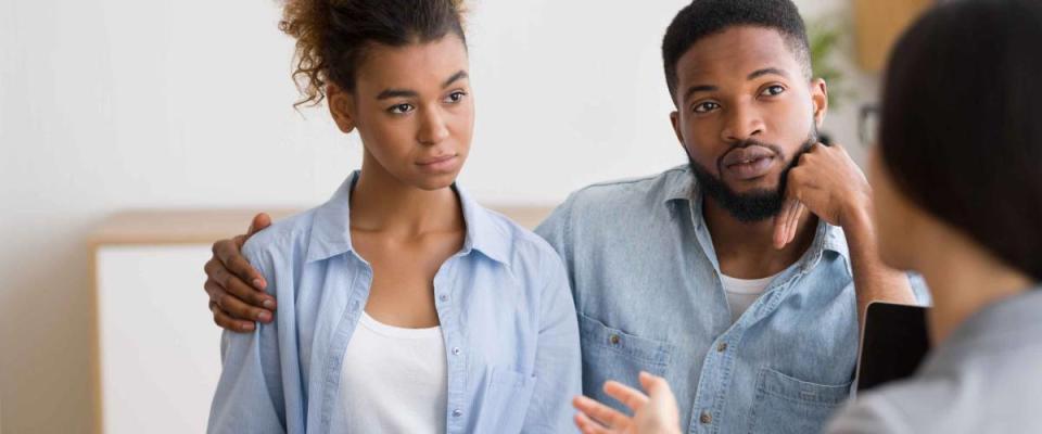 Serious Young Afro Couple Listening To Their Investment Counselor During Financial Consultation In Office. Selective Focus