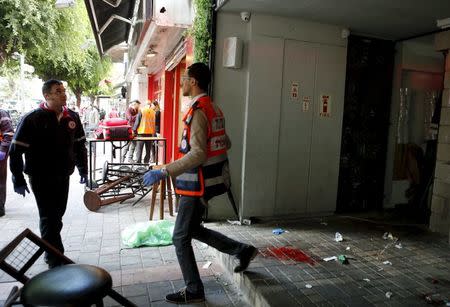 Rescue personnel walk next to blood stains at the scene of a shooting rampage by Israeli Arab Nashat Melhem at a bar in Tel Aviv, Israel, in this January 1, 2016 file picture. REUTERS/Nir Elias/Files