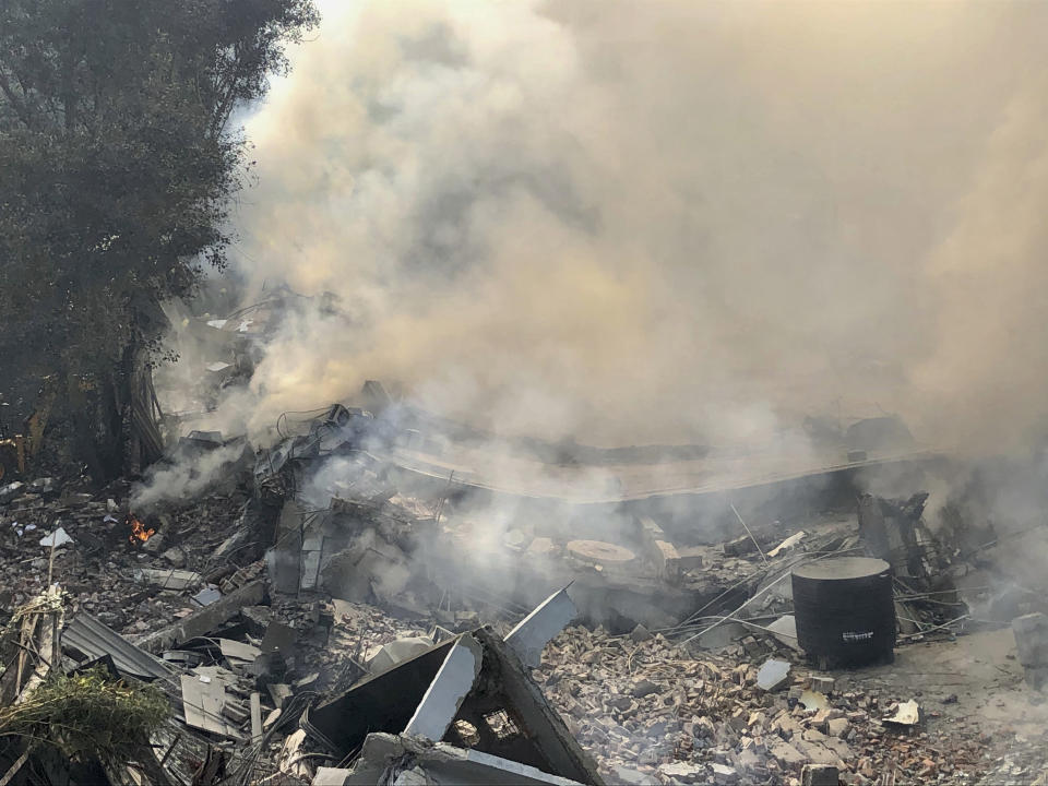 Smoke rises after a factory caught fire and collapsed in Peera Garhi area in western New Delhi, India, Thursday, Jan. 2, 2020. Several people, including some fire officials were injured. (AP Photo/Manish Swarup)