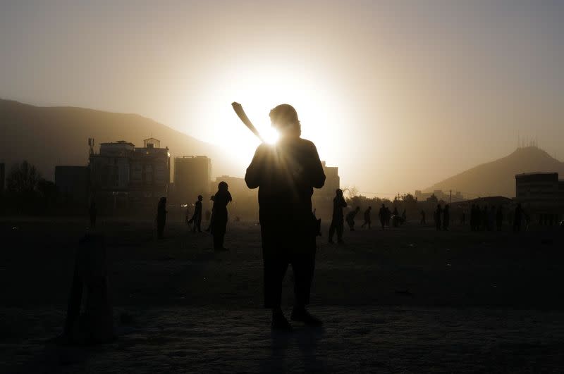 Hikmatullah, 30, holds his bat as he plays cricket at a playground in Kabul