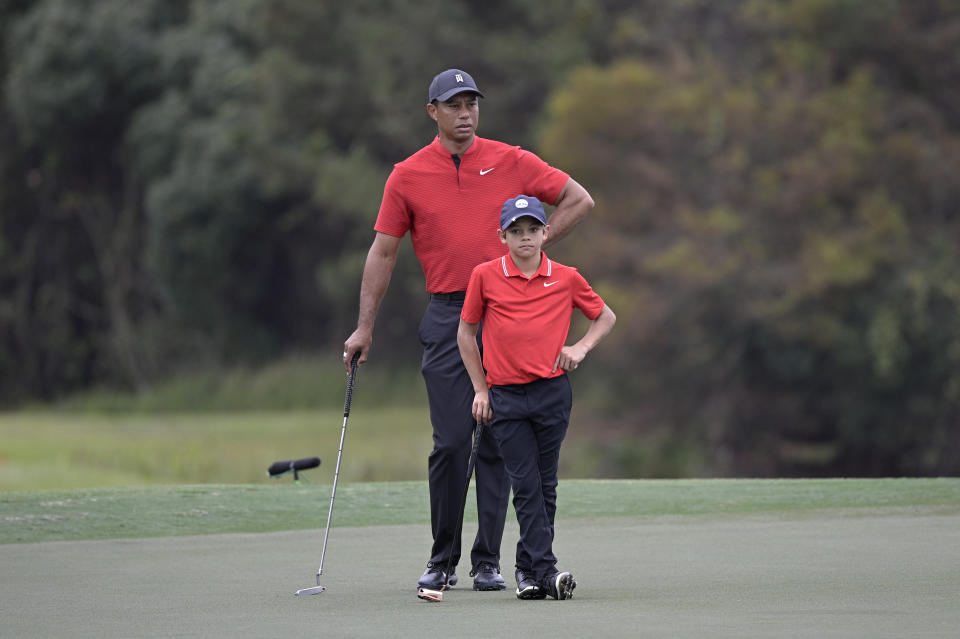 Tiger Woods and his son Charlie wait to putt on the 12th green during the final round of the PNC Championship golf tournament, Sunday, Dec. 20, 2020, in Orlando, Fla. (AP Photo/Phelan M. Ebenhack)