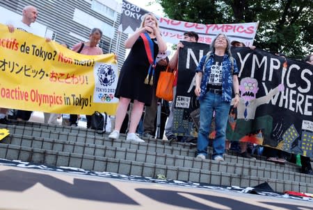 People protest against the Tokyo 2020 Olympics on the day marking one year out from the start of the summer games, at Shinjuku district in Tokyo