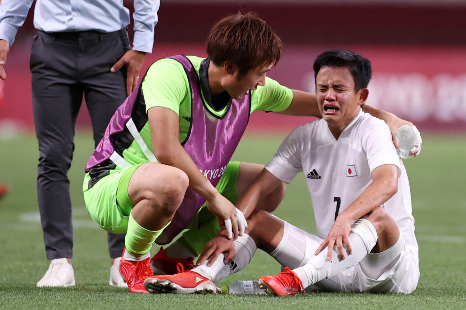 SAITAMA, JAPAN - AUGUST 06: Takefusa Kubo #7 of Team Japan looks dejected as he is consoled by Keisuke Osako #1 of Team Japan following defeat in the Men's Bronze Medal Match between Mexico and Japan on day fourteen of the Tokyo 2020 Olympic Games at Saitama Stadium on August 06, 2021 in Saitama, Tokyo, Japan. (Photo by Koki Nagahama/Getty Images)