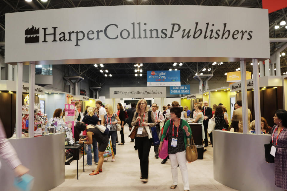 FILE - This May 28, 2015 file photo shows attendees at the HarperCollins Publishers booth during BookExpo America in New York. Publishing's annual national convention, BookExpo, has been postponed until July. Organizers cited concerns about the coronavirus in rescheduling the gathering, originally scheduled to take place in late May at the Jacob Javits Convention Center in Manhattan. (AP Photo/Mark Lennihan, File)