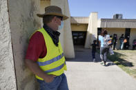 Dave, left, who declined to give his last name, from Toledo, Ohio, wears a neon vest as migrants are released from U.S. Customs and Border Protection custody, Friday, Sept. 24, 2021, in Del Rio, Texas. Dave, who has been to Haiti many times, befriended a woman named Ruth, who he believes is still in custody after she crossed the Rio Grande with her husband and their 3-year-old daughter. Dave drove down from Ohio to Southwest Texas in hopes of picking the family up and driving them to Ohio, where Ruth has family awaiting them. (AP Photo/Julio Cortez)