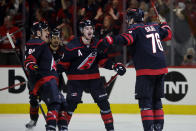 Carolina Hurricanes' Brady Skjei (76) is congratulated by teammates Bradly Nadeau (29) and Teuvo Teravainen (86) after his winning goal during the third period in Game 4 of an NHL hockey Stanley Cup second-round playoff series against the New York Rangers in Raleigh, N.C., Saturday, May 11, 2024. (AP Photo/Karl B DeBlaker)