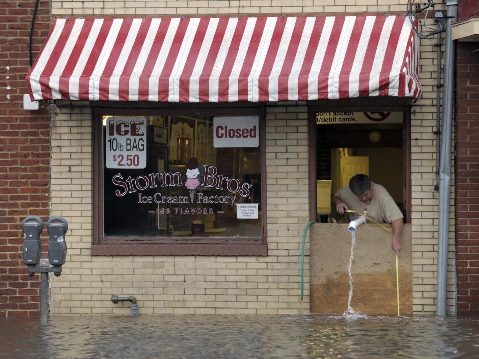 Sveinn Storm, owner of Storm Bros. Ice Cream Factory measures the flood waters outside his store in Annapolis, Md., Tuesday, Oct. 30, 2012, in the aftermath of Superstorm Sandy that passed through the East Coast. (AP Photo/Susan Walsh)