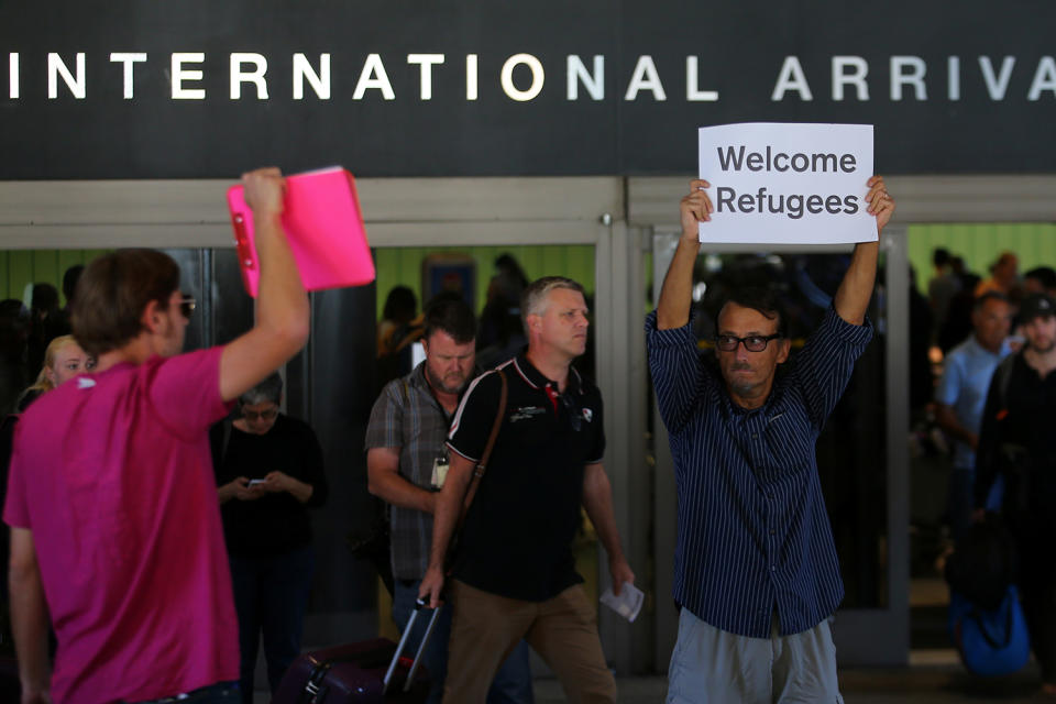 <p>Retired engineer John Wider, 59, is greeted by a supporter of U.S. President Donald Trump as he holds up a sign reading “Welcome Refugees” at the international arrivals terminal at Los Angeles International Airport in Los Angeles, California, U.S., June 29, 2017. (Mike Blake/Reuters) </p>