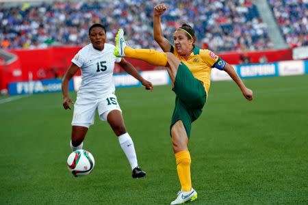 Jun 12, 2015; Winnipeg, Manitoba, CAN; Australia forward Lisa De Vanna (11) clears the ball in front of Nigeria defender Ugo Njoku (15) during the second half in a Group D soccer match in the 2015 FIFA women's World Cup at Winnipeg Stadium. Mandatory Credit: Michael Chow-USA TODAY Sports