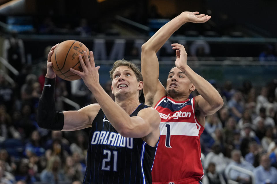 Orlando Magic's Moritz Wagner (21) looks to the basket in front of Washington Wizards guard Johnny Davis (1) during the first half of an NBA basketball game Friday, Dec. 1, 2023, in Orlando, Fla. (AP Photo/John Raoux)