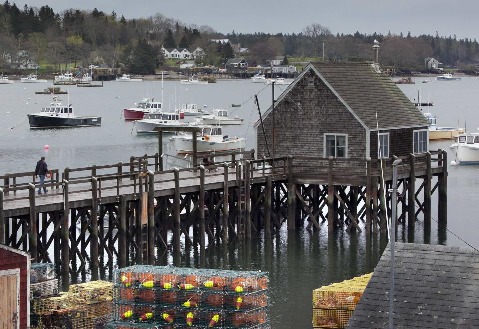 A man walks out on a wharf in Friendship, Maine, Thursday, May 10, 2012. Two lobster boats were recently sunk by vandals in Friendship. The dispute among tightlipped lobstermen points to the unwritten laws of the sea: Fishermen mete out justice themselves, sometimes with violent results.(AP Photo/Robert F. Bukaty)