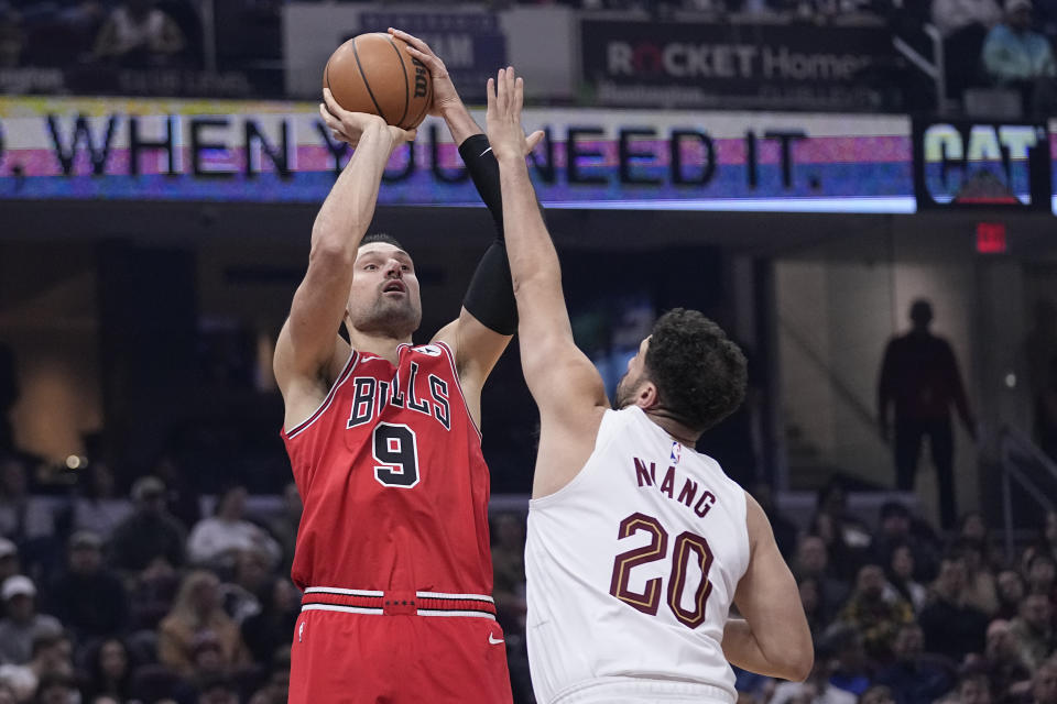 Chicago Bulls center Nikola Vucevic (9) looks to shoot as Cleveland Cavaliers forward Georges Niang (20) defends in the first half of an NBA basketball game, Monday, Jan. 15, 2024, in Cleveland. (AP Photo/Sue Ogrocki)