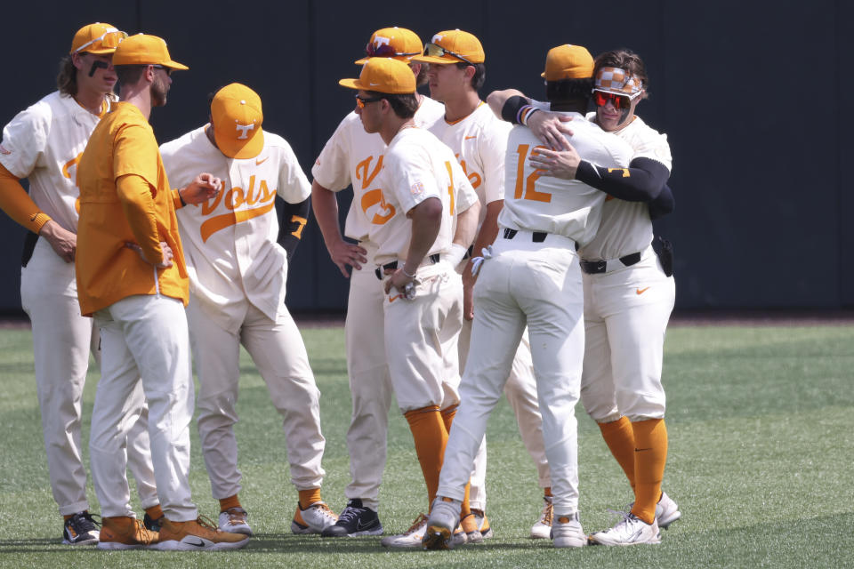 Tennessee's Kyle Booker (12) hugs Drew Gilbert after Tennessee lost to Notre Dame in an NCAA college baseball super regional game Sunday, June 12, 2022, in Knoxville, Tenn. Notre Dame won 7-3 to advance to the College World Series. (AP Photo/Randy Sartin)