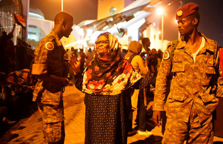 Sudanese demonstrator walks between the military during celebrations after the Defence Minister Awad Ibn Auf stepped down as head of the country's transitional ruling military council, as protesters demanded quicker political change, outside the Defence Ministry in Khartoum, Sudan April 13, 2019. REUTERS/Stringer