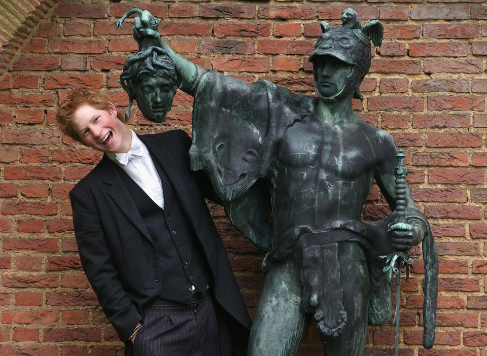 Prince Harry poses next to a bronze statue of Perseus holding the Gorgon's head on May 12, 2003, in the King of Siam's Gardens at Eton College.