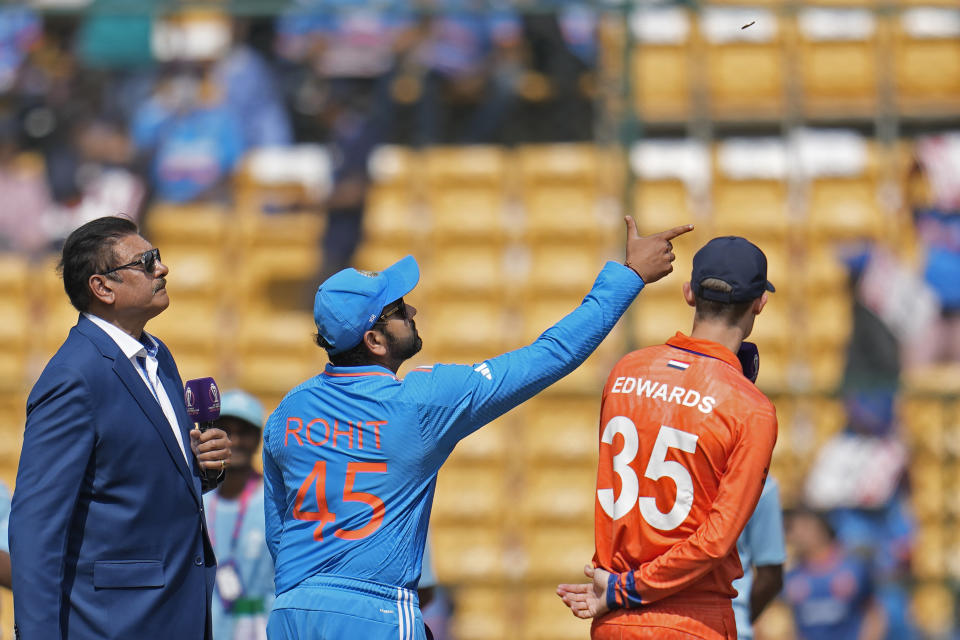 Netherlands' captain Scott Edwards, right, watches as India's captain Rohit Sharma, center, spins the coin at toss before the start of the ICC Men's Cricket World Cup match between India and Netherlands in Bengaluru, India, Sunday, Nov. 12, 2023. (AP Photo/Aijaz Rahi)